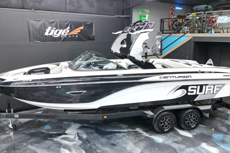 Slide: The Image of 2017 Centurion Ri237 surf boat on display in showroom with Tige Boats banner. - 29