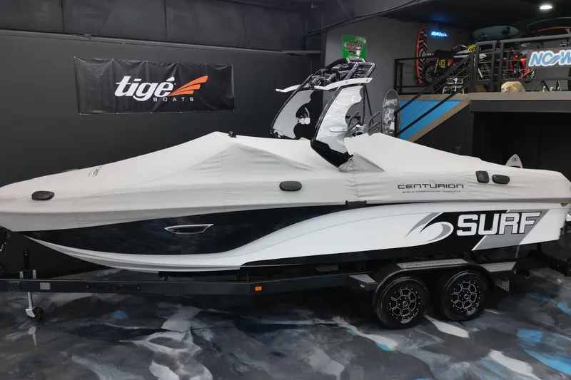 Slide: The Image of 2017 Centurion Ri237 surf boat with cover on trailer in showroom. - 3