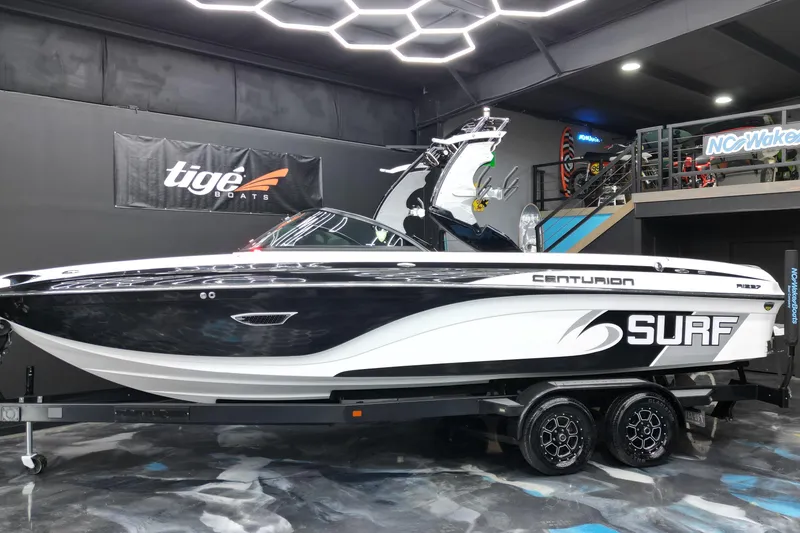 Slide: The Image of 2017 Centurion Ri237 surf boat displayed indoors on a trailer. - 30