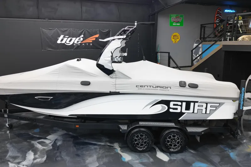 Slide: The Image of 2017 Centurion Ri237 surf boat covered on trailer in showroom. - 4