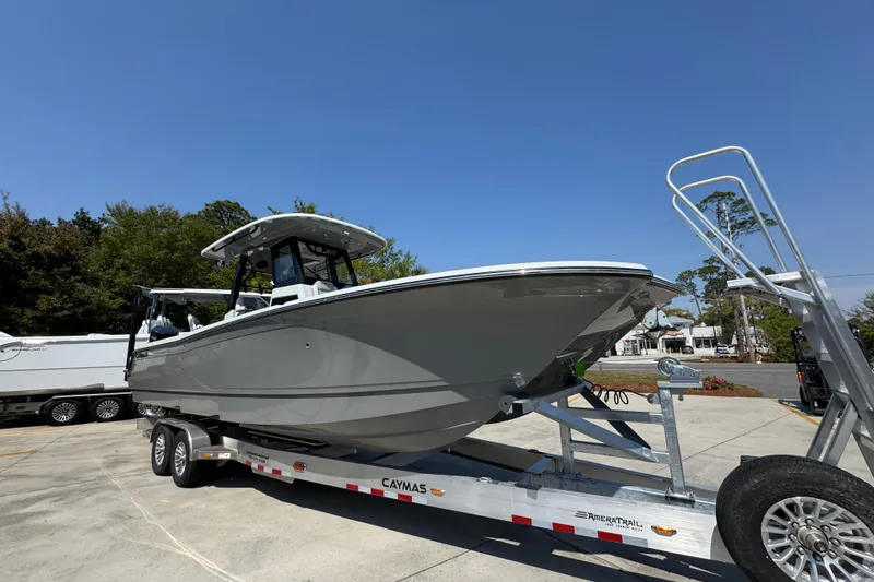 Slide: The Image of 2026 Caymas 29 CT boat on trailer, parked outdoors under clear blue sky. - 8