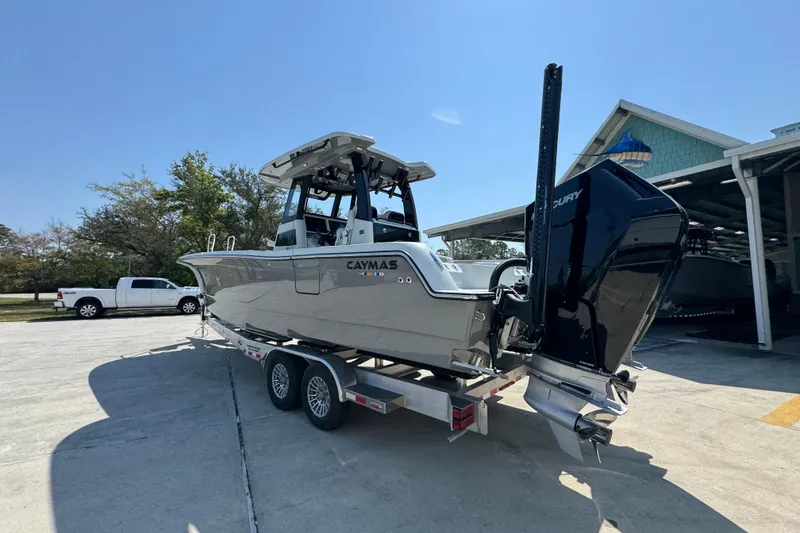 Slide: The Image of 2026 Caymas 29 CT boat on trailer, parked outdoors under clear sky. - 17