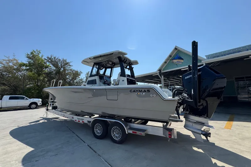 Slide: The Image of 2026 Caymas 29 CT boat on trailer, parked outdoors under clear sky. - 18