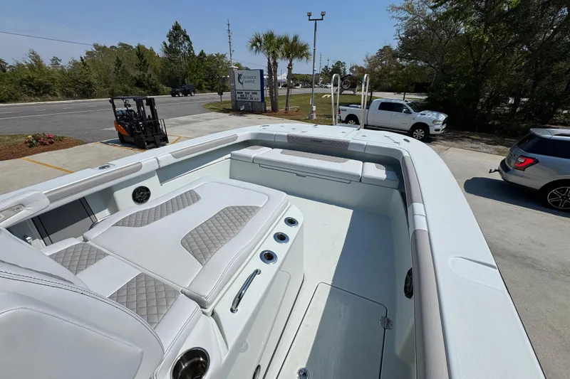 Slide: The Image of 2026 Caymas 29 CT boat with spacious seating and modern design in a parking lot. - 24