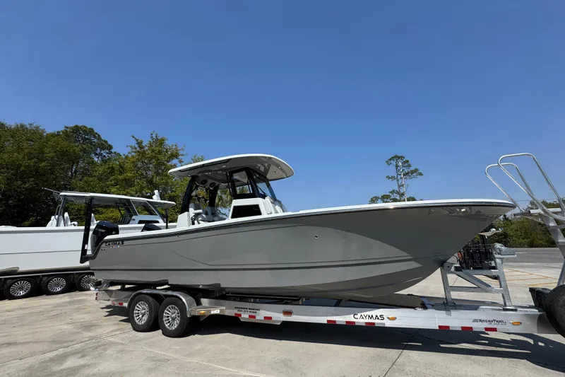Slide: The Image of 2026 Caymas 29 CT boat on trailer, parked outdoors under clear blue sky. - 9