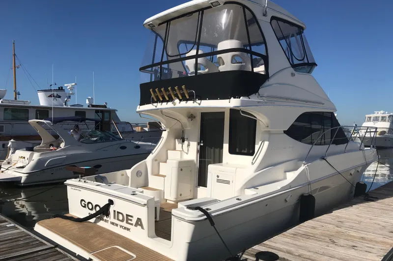 The Image of 2005 Silverton 38 Convertible yacht docked at marina under clear blue sky. - 0