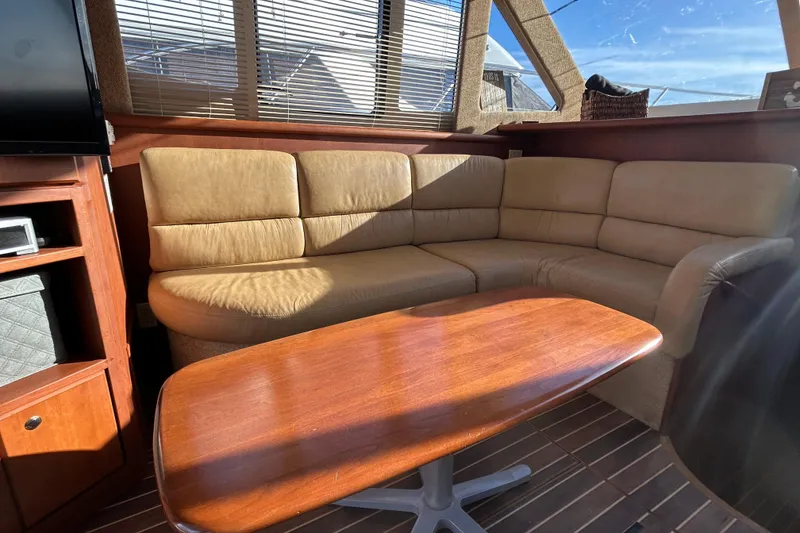 Slide: The Image of Luxurious interior of 2005 Silverton 38 Convertible yacht with leather seating and wooden table. - 11
