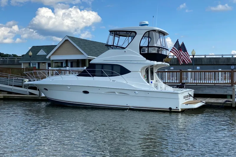 Slide: The Image of 2005 Silverton 38 Convertible yacht docked at marina with American flags. - 3