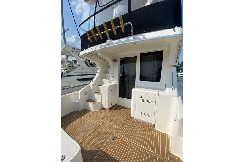 Slide: The Image of 2005 Silverton 38 Convertible yacht deck with wood flooring and storage compartments. - 4