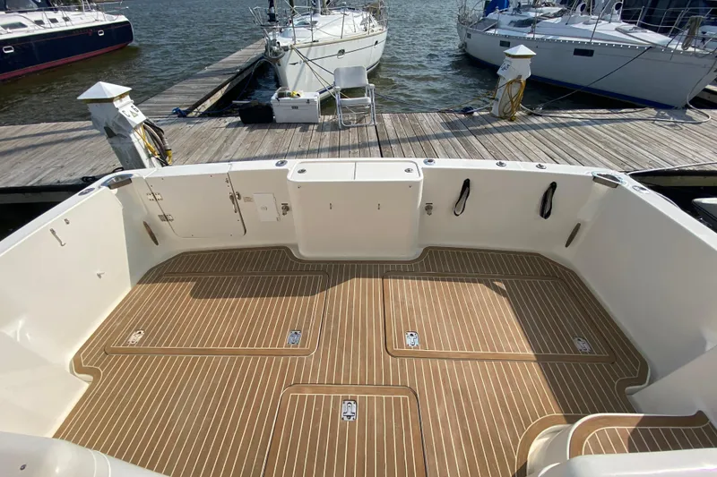 Slide: The Image of 2005 Silverton 38 Convertible boat deck with wood finish, docked at marina. - 5