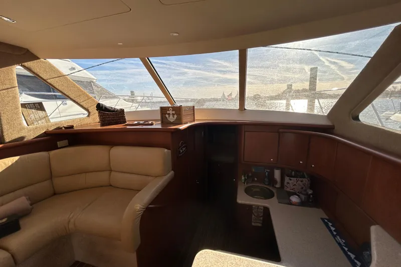 Slide: The Image of Interior of 2005 Silverton 38 Convertible yacht with beige seating and wooden cabinetry. - 7