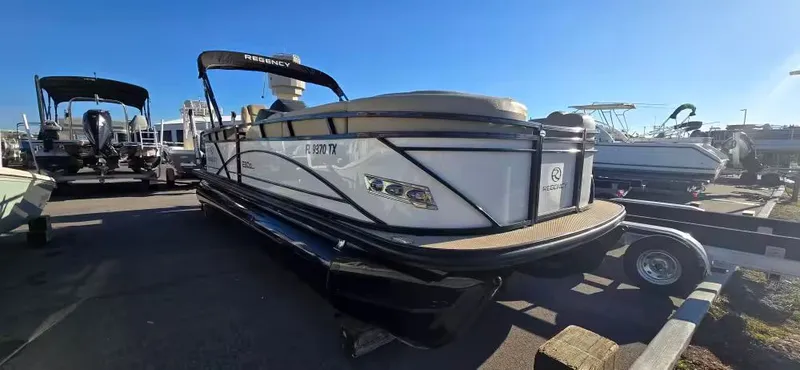 The Image of 2020 Regency 230 DL3 pontoon boat on a trailer outdoors. - 1