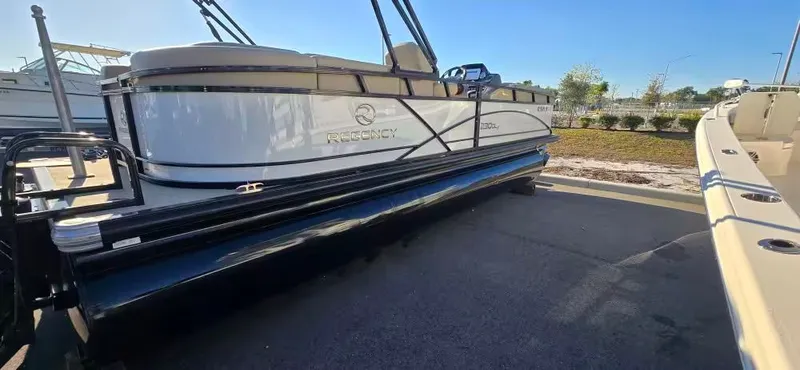 Slide: The Image of 2020 Regency 230 DL3 pontoon boat parked outdoors. - 3
