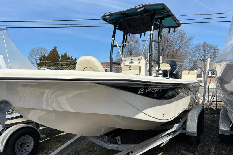 The Image of 2023 Carolina Skiff 21 LS boat on trailer, featuring a sleek design and T-top canopy. - 0