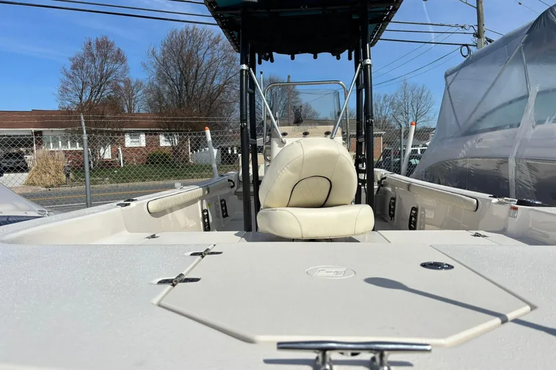 Slide: The Image of 2023 Carolina Skiff 21 LS boat interior with seating and console, parked outdoors. - 11