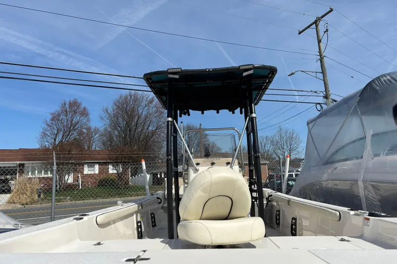 Slide: The Image of 2023 Carolina Skiff 21 LS boat with T-top, parked outdoors under clear blue sky. - 12