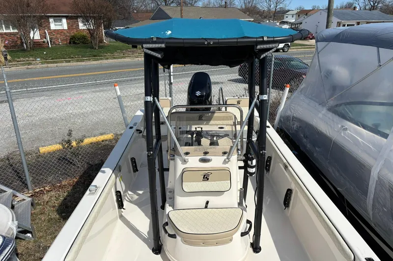 Slide: The Image of 2023 Carolina Skiff 21 LS boat with blue canopy, parked near a road. - 9