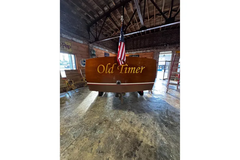 Slide: The Image of 1948 Chris-Craft Sportster 25 boat named "Old Timer" in a rustic garage setting. - 10