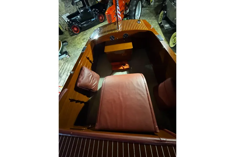 Slide: The Image of 1948 Chris-Craft Sportster 25 boat interior with vintage wooden design and red leather seating. - 13