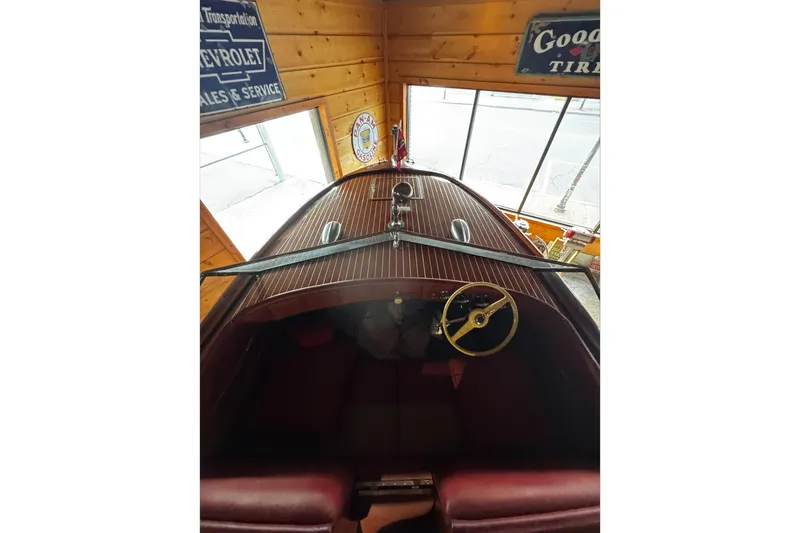 Slide: The Image of 1948 Chris-Craft Sportster 25 boat interior with wooden dashboard and vintage steering wheel. - 14