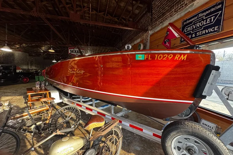 Slide: The Image of 1948 Chris-Craft Sportster 25 boat on trailer in vintage garage setting. - 2