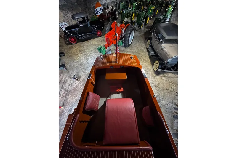 Slide: The Image of 1948 Chris-Craft Sportster 25 boat in vintage garage with classic cars and tractors. - 3