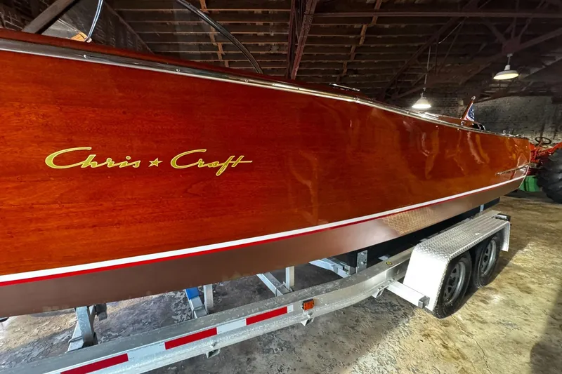 Slide: The Image of 1948 Chris-Craft Sportster 25 boat on trailer, showcasing polished wooden hull. - 4