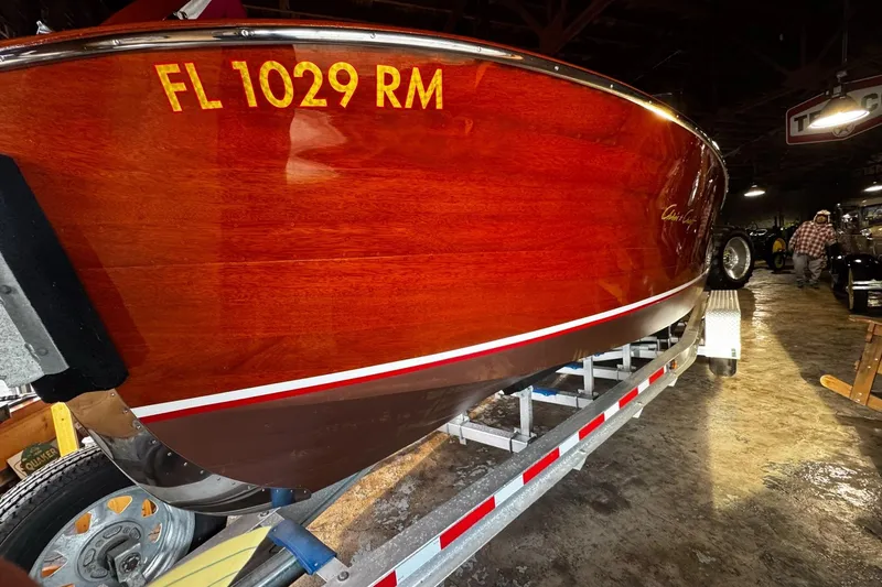 Slide: The Image of 1948 Chris-Craft Sportster 25 boat on trailer, showcasing polished wooden hull indoors. - 5