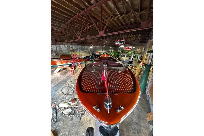 Slide: The Image of 1948 Chris-Craft Sportster 25 in vintage garage with classic decor and motorcycles. - 9