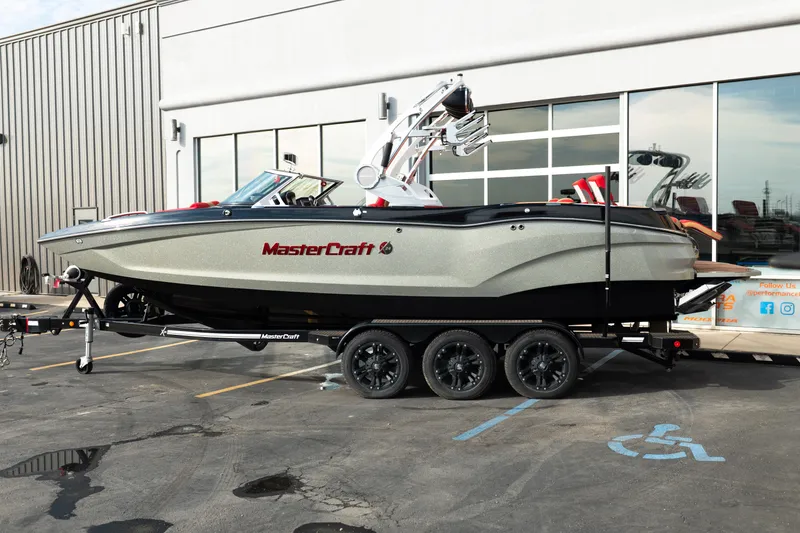 Slide: The Image of 2021 MasterCraft X24 boat on trailer outside a building. - 2
