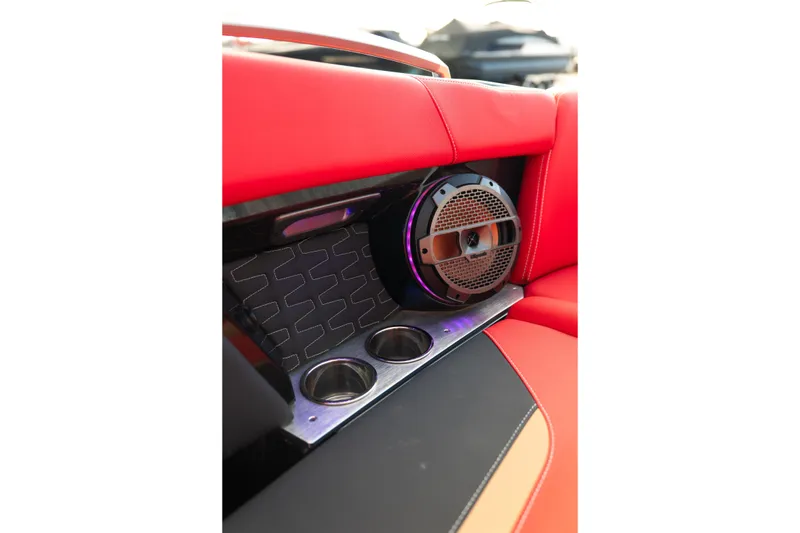 Slide: The Image of 2021 MasterCraft X24 interior with red upholstery, speaker, and cup holders. - 23