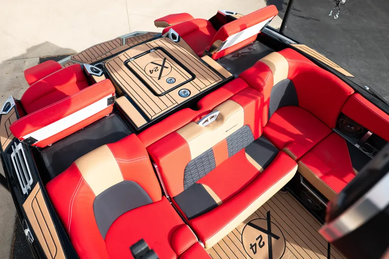 Slide: The Image of 2021 MasterCraft X24 boat interior with red and tan seating, featuring stylish design and logo. - 26