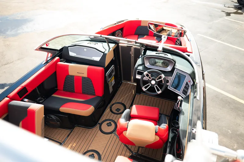 Slide: The Image of 2021 MasterCraft X24 boat interior with red and black seating, modern dashboard, and sleek design. - 27