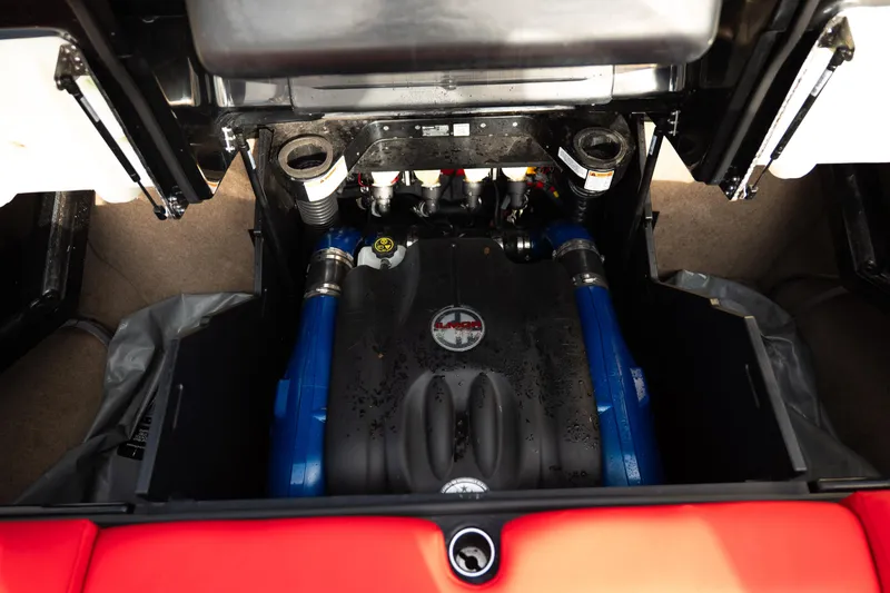 Slide: The Image of Engine compartment of a 2021 MasterCraft X24 boat, featuring blue hoses and detailed components. - 28