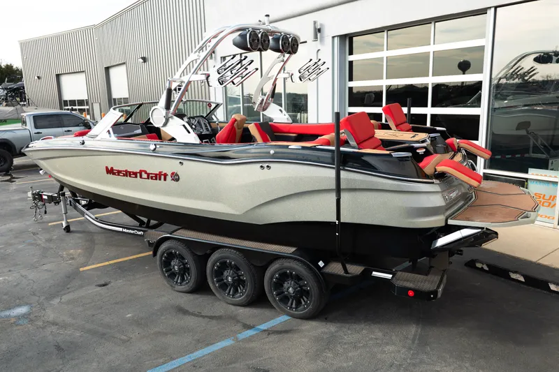 Slide: The Image of 2021 MasterCraft X24 boat on trailer, featuring sleek design and red seating. - 3