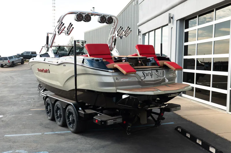 Slide: The Image of 2021 MasterCraft X24 boat on trailer with red seats and surf design. - 4