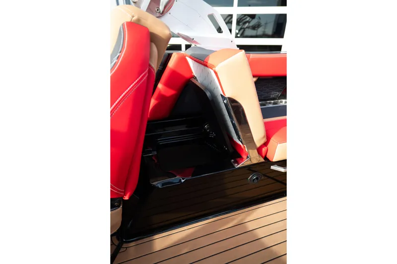 Slide: The Image of 2021 MasterCraft X24 boat interior with red and beige seating, showcasing storage compartment. - 40