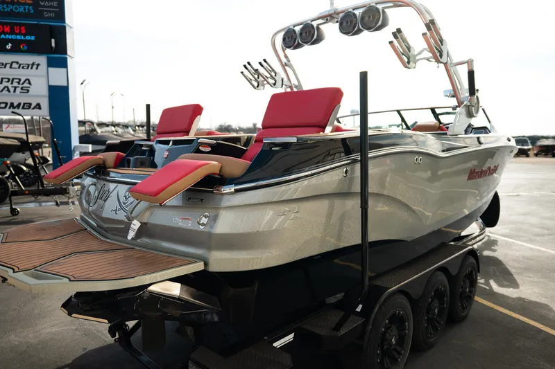Slide: The Image of 2021 MasterCraft X24 boat with red seats on a trailer, displayed outdoors. - 7