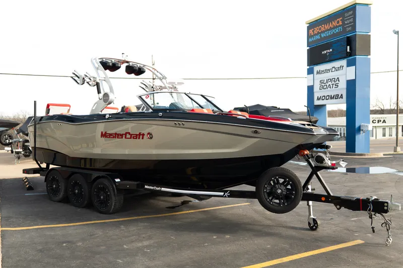 Slide: The Image of 2021 MasterCraft X24 boat on trailer at dealership parking lot. - 9
