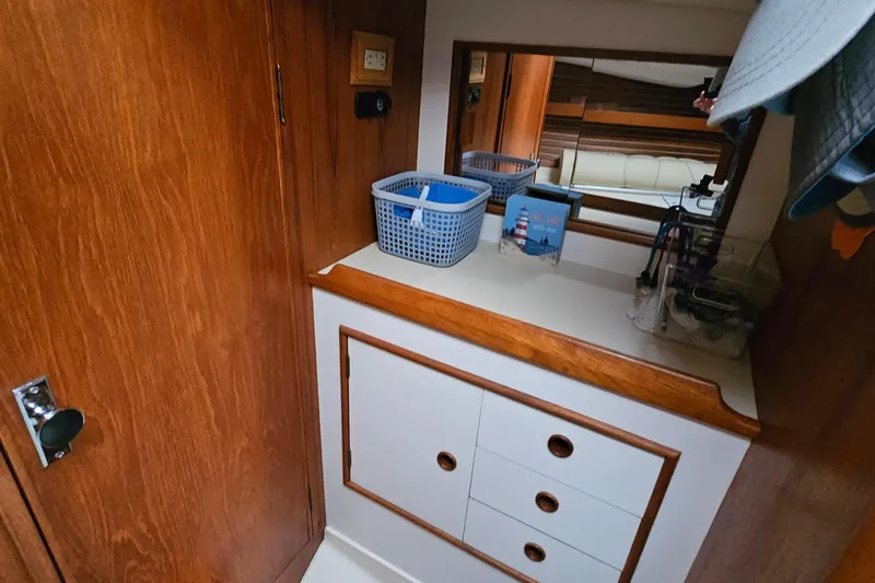 Slide: The Image of Interior of 1985 Nonsuch 30 sailboat with wooden cabinetry and storage baskets. - 10