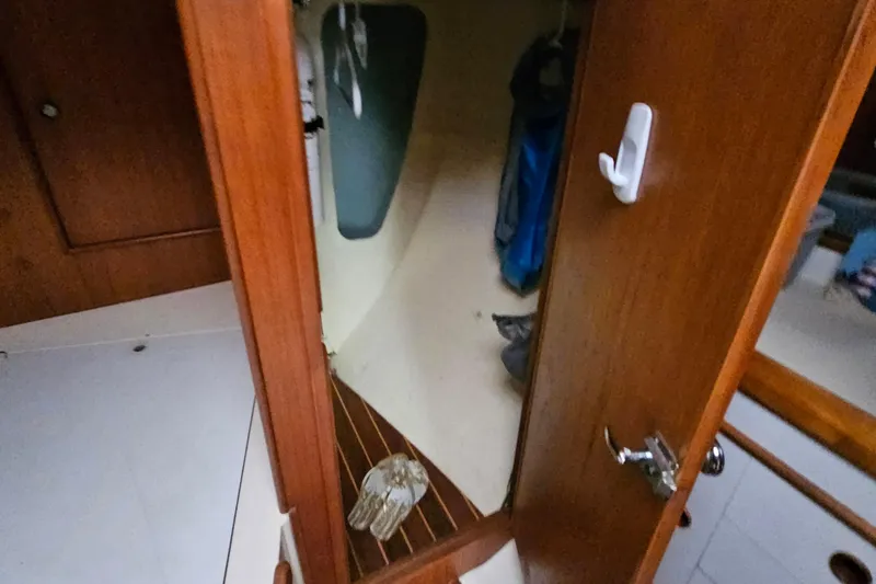 Slide: The Image of Interior view of a 1985 Nonsuch 30 sailboat cabin with wooden door and storage. - 11