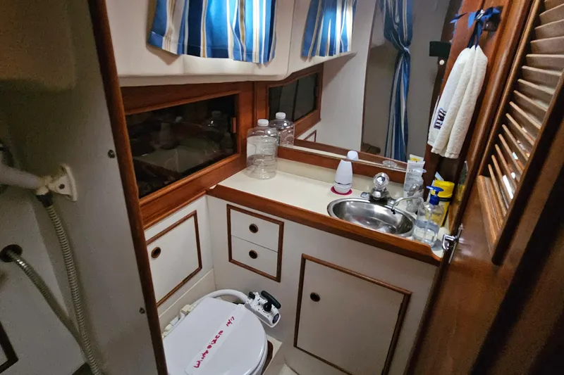 Slide: The Image of Compact bathroom in a 1985 Nonsuch 30 sailboat with sink, toilet, and storage. - 12