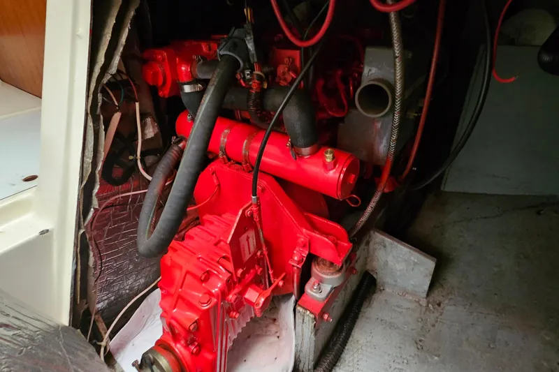 Slide: The Image of Engine compartment of a 1985 Nonsuch 30 sailboat, featuring a red-painted engine. - 14