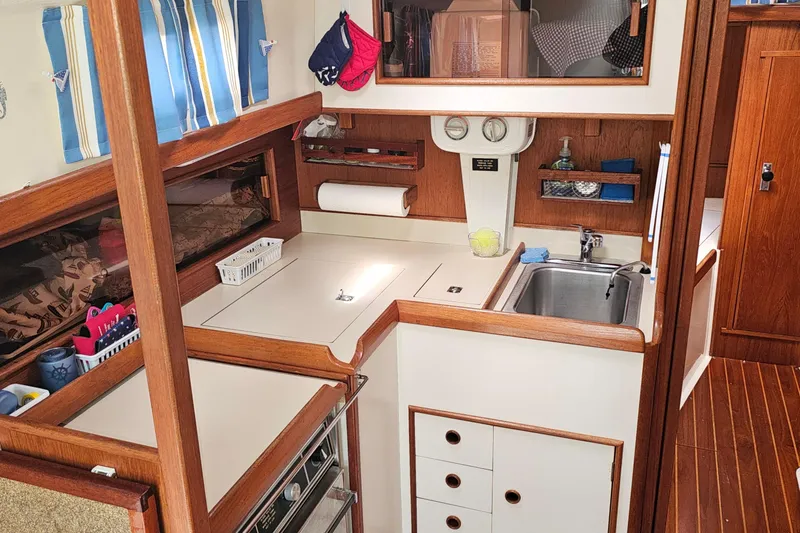 Slide: The Image of Cozy 1985 Nonsuch 30 sailboat galley with wood accents and compact kitchen amenities. - 20