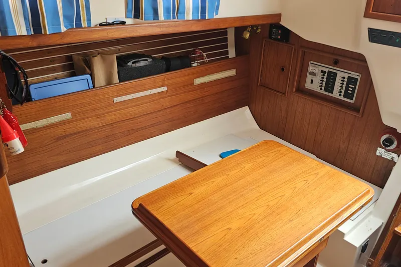 Slide: The Image of Interior of a 1985 Nonsuch 30 sailboat with wooden table and storage compartments. - 21