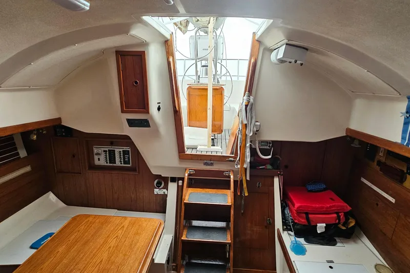 Slide: The Image of Interior of a 1985 Nonsuch 30 sailboat, featuring wooden cabinetry and compact design. - 6