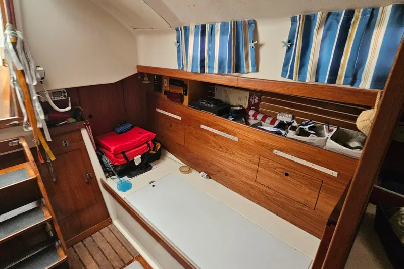 Slide: The Image of Interior of 1985 Nonsuch 30 sailboat with wooden cabinetry and striped curtains. - 8