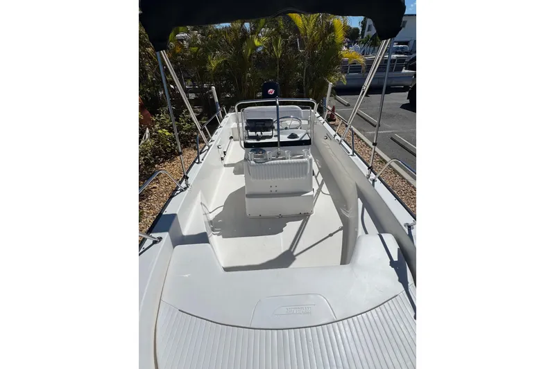 Slide: The Image of 2003 Boston Whaler 170 Montauk boat with center console and seating, docked outdoors. - 10