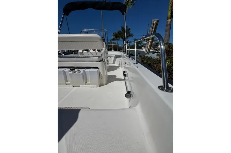 Slide: The Image of 2003 Boston Whaler 170 Montauk boat interior with seating and railing under clear blue sky. - 5