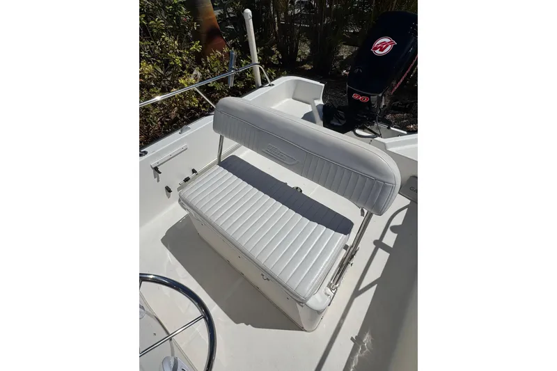 Slide: The Image of 2003 Boston Whaler 170 Montauk boat interior with white cushioned seating. - 7